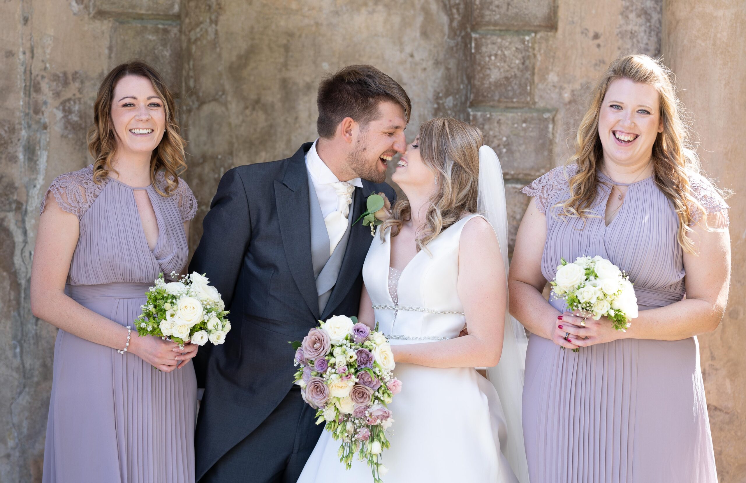 wedding couple laughing during photos with bridesmaids and Bournemouth wedding photographer